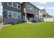 Spacious backyard with artificial turf, patio, and elegant stone accents to enhance outdoor living and enjoyment at 17121 Desert Wine Ln, Parker, CO 80134