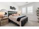 Well-lit bedroom featuring neutral tones, shuttered windows, and a striking black headboard at 17121 Desert Wine Ln, Parker, CO 80134