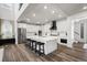 Modern kitchen with a large island, white cabinets, stainless steel appliances, and a stylish black range hood at 17121 Desert Wine Ln, Parker, CO 80134