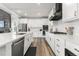 Modern kitchen with white cabinets, stainless steel appliances, quartz countertops, and a sleek black range hood at 17121 Desert Wine Ln, Parker, CO 80134