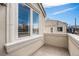 Balcony with stone flooring and stucco walls overlooking blue sky at 375 Josephine St # D, Denver, CO 80206