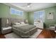 Staged bedroom with a king bed, modern lamps, windows, and a ceiling fan at 375 Josephine St # D, Denver, CO 80206