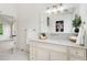 Bright bathroom with white cabinetry, neutral countertop, and a decorative mirror with modern lighting at 13483 Alcott Way, Broomfield, CO 80020