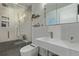 A modern bathroom with a sleek shower, floating shelves, and minimalist design at 5557 Aspen Ave, Erie, CO 80516