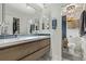 Modern bathroom featuring a double vanity, tile flooring, and a walk-in closet at 5557 Aspen Ave, Erie, CO 80516