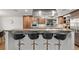 Close-up of the kitchen island with seating and stainless steel appliances at 5557 Aspen Ave, Erie, CO 80516