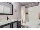 Modern bathroom featuring a vanity sink with dark fixtures, framed mirror, and a shower-tub combination at 10779 Longs Way, Parker, CO 80138