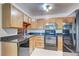 Bright kitchen with wood cabinets, granite counters, and black appliances at 3082 S Wheeling Way # 408, Aurora, CO 80014