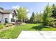 Lush backyard with a well-manicured lawn, trees, patio, and inviting outdoor seating area at 3445 S Clermont St, Denver, CO 80222