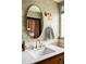 Elegant bathroom featuring a marble countertop, gold fixtures, and stylish wallpaper at 3445 S Clermont St, Denver, CO 80222