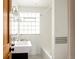 Modern bathroom featuring black and white tile, tub, and glass block window at 3445 S Clermont St, Denver, CO 80222