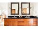 Bathroom with wood vanity, dual sinks, large mirrors and modern lighting at 3445 S Clermont St, Denver, CO 80222