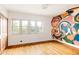 Bright bedroom with wood floors, colorful wall art and double door closet at 3445 S Clermont St, Denver, CO 80222