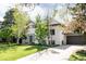 Charming two-story home with a well-manicured lawn and a long concrete driveway leading to an attached two car garage at 3445 S Clermont St, Denver, CO 80222