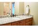 Well-lit bathroom featuring a granite countertop vanity with wood cabinets and modern fixtures at 1120 Brenthaven Ct, Monument, CO 80132