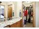 Bathroom featuring a granite countertop vanity, a walk in closet, and doorway to an adjacent bedroom at 1120 Brenthaven Ct, Monument, CO 80132