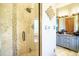 Luxurious shower with glass door and tiled walls, next to a vanity with a vessel sink in an elegant bathroom at 1120 Brenthaven Ct, Monument, CO 80132
