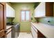 Functional laundry room with plenty of counter and cabinet space, stainless steel washer and dryer, and views of the mountains at 1120 Brenthaven Ct, Monument, CO 80132