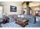 Warm living room featuring a plush sofa, a decorative rug, and an ornate coffee table, creating an inviting space at 1120 Brenthaven Ct, Monument, CO 80132