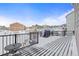 View of a snow-covered back deck with a grill, chairs, and a small table overlooking the neighborhood at 19814 Lindenmere Dr, Monument, CO 80132