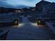 Inviting backyard patio with walkway and stone columns lit at night at 19814 Lindenmere Dr, Monument, CO 80132