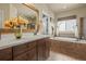 Elegant bathroom featuring tile surround bathtub, large mirror and modern fixtures at 19814 Lindenmere Dr, Monument, CO 80132