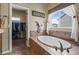 Relaxing bathroom featuring tile surround tub, natural light and a walk-in closet at 19814 Lindenmere Dr, Monument, CO 80132