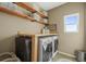 Functional laundry room with open shelving, countertop, modern washer and dryer at 19814 Lindenmere Dr, Monument, CO 80132