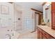 Spa-like bathroom features a glass block walk-in shower, soaking tub, and wood vanity at 78 Fairway Ln, Littleton, CO 80123