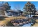 Exterior of home with manicured lawn, stone landscaping, mature trees, and grey roof at 78 Fairway Ln, Littleton, CO 80123