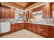 Well-lit kitchen features wooden cabinets, tile backsplash and floors, and modern appliances at 78 Fairway Ln, Littleton, CO 80123