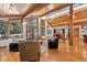 Bright living room features hardwood floors, wood ceiling beams and many windows offering plenty of natural light at 78 Fairway Ln, Littleton, CO 80123