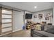 Basement featuring a sliding barn door, television, shelving, gray couch, and neutral carpet at 6476 Silver Mesa Dr # A, Highlands Ranch, CO 80130