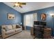 Cozy bedroom with blue walls, a ceiling fan, a window with curtains, and a work space with a desk and chair at 6476 Silver Mesa Dr # A, Highlands Ranch, CO 80130