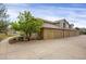 Townhouse exterior showing attached garages, neutral paint, small side yard and concrete driveway at 6476 Silver Mesa Dr # A, Highlands Ranch, CO 80130