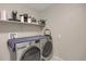 Laundry room featuring a washer and dryer, shelf, and white walls at 6476 Silver Mesa Dr # A, Highlands Ranch, CO 80130