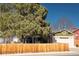 Charming home with a wooden fence and a tree-lined yard at 14991 E Elk Pl, Denver, CO 80239