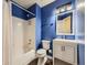 Bright bathroom featuring blue walls, a shower-tub combo, and a white vanity at 378 Benton St, Castle Rock, CO 80104