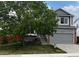 Charming two-story home with gray exterior, landscaped yard, and mature tree in the front at 378 Benton St, Castle Rock, CO 80104