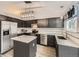 Modern kitchen featuring black cabinets, stainless steel appliances, granite countertops, and stylish lighting fixtures at 378 Benton St, Castle Rock, CO 80104