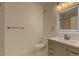 Bathroom showcasing a vanity with an illuminated mirror, a toilet, and decorative wallpaper at 2809 Syracuse Ct # 129, Denver, CO 80238