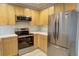 Bright kitchen with stainless steel appliances, chic backsplash, and wood cabinets offering plenty of storage at 2809 Syracuse Ct # 129, Denver, CO 80238