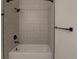 Close-up of bathtub and tiled shower with bronze fixtures and decorative gray patterned tile at 2809 Syracuse Ct # 129, Denver, CO 80238