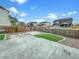 Backyard with concrete and turf areas, surrounded by a wood fence, with other homes visible at 11650 Lewiston Ct, Commerce City, CO 80022