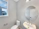 Half bath with stylish oval mirror and fixtures, plus a window with a view at 11650 Lewiston Ct, Commerce City, CO 80022