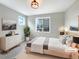Serene staged bedroom with a large window, neutral decor, and minimalist furniture at 11650 Lewiston Ct, Commerce City, CO 80022