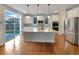 Modern kitchen featuring a large island, stainless steel appliances, and hardwood floors at 11650 Lewiston Ct, Commerce City, CO 80022