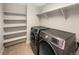 Laundry room with side-by-side washer and dryer, shelving, and tile flooring at 11650 Lewiston Ct, Commerce City, CO 80022