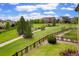 Lush backyard featuring green lawn, walking path, and trees under a beautiful sky at 26143 E Fremont Pl, Aurora, CO 80016