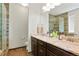 Elegant bathroom with double vanity, granite counters, decorative mirrors, and a glass-enclosed shower at 26143 E Fremont Pl, Aurora, CO 80016